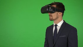 A young businessman uses VR glasses - green screen studio - Powered by Shutterstock - Get 15% off with code: PIKWIZARD15