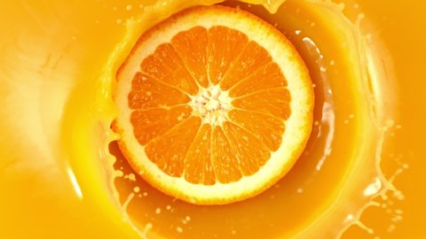 Super Slow Motion Shot of Fresh Orange Slice Splashing to Orange Juice at 1000fps.