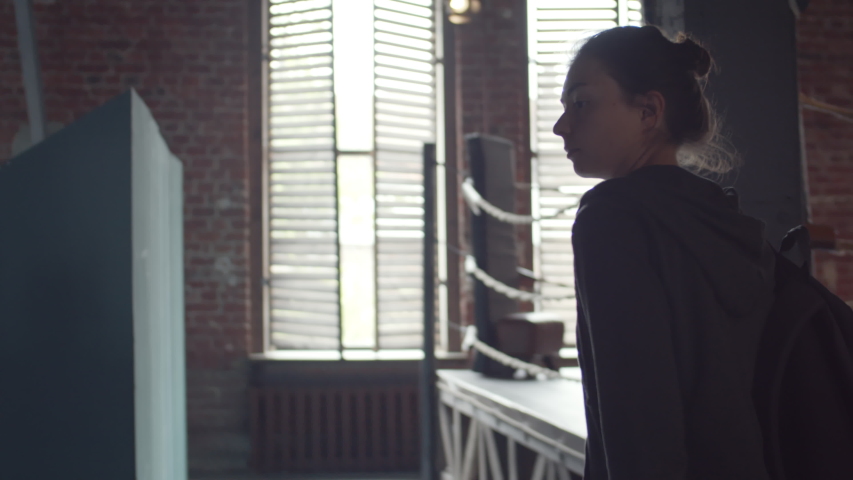 Back view of two female friends coming to lock room, greeting each other by bumping their fists then putting their backpacks on bench