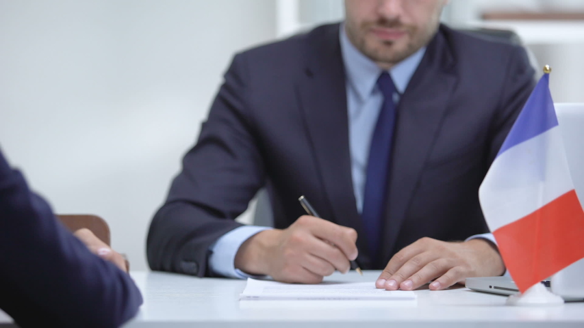 French official signing docs about state business support, shaking partner hand Royalty-Free Stock Footage #1036588949
