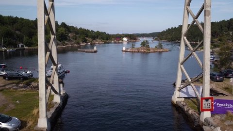 Lillesand , Aust-Agder / Norway - 08 04 2019: Small boat crossing Justoya bridge, Flying through bridge