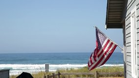 A beautiful oceanfront property with a classic American flag on the side of it with the coastline in the background. - Powered by Shutterstock - Get 15% off with code: PIKWIZARD15