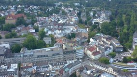 Aerial view of the city Baden-Baden in Germany on a sunny morning in summer. Pan to the left with tilt down beside the city.