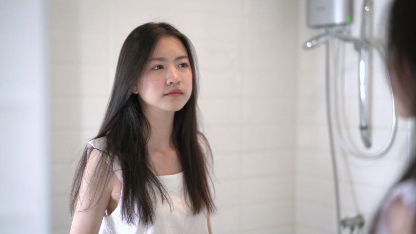 Young beautiful asian woman look at mirror problem acne on face her strain after wake up in the morning in bathroom 4k resolution. Royalty-Free Stock Footage #1036606634