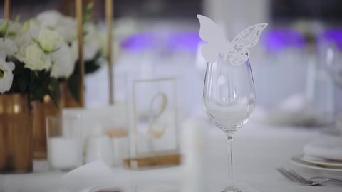 fashionable wedding table decoration with white flower bouquets decorative butterflies and number sign slow motion close