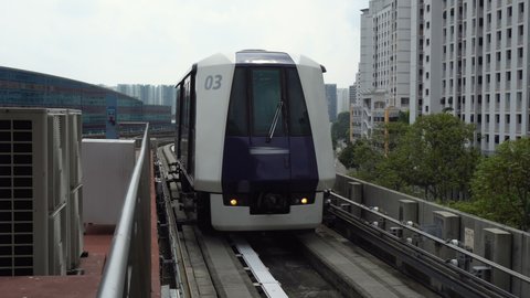 Futuristic Autonomous Train Driving on Elevated Tracks Arriving at Station in City of Singapore วิดีโอสต็อก