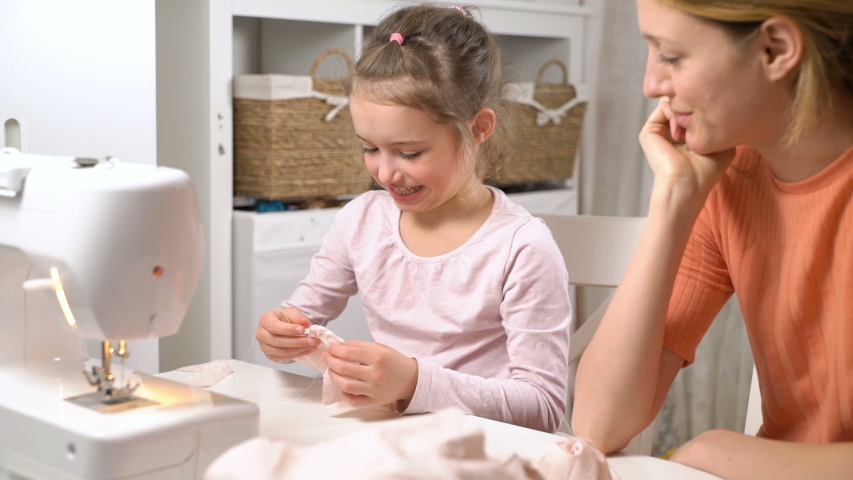 Mother teaching her little daughter to sew using needle and thread in the nursery at home. Children's craft, education and training | Shutterstock HD Video #1036633874