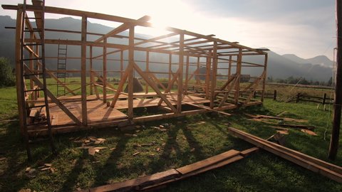 Frame of eco wood farm construction in mountain village at sunset time