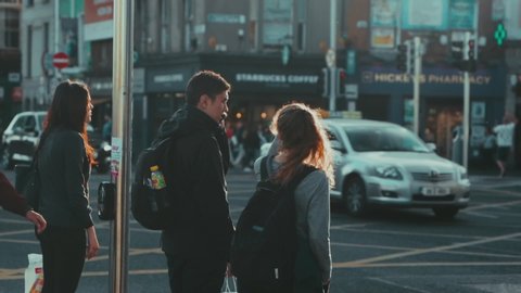 Dublin / Ireland - 06 18 2018: A couple waiting on a crosswalk on a windy afternoon in Dublin, Ireland.