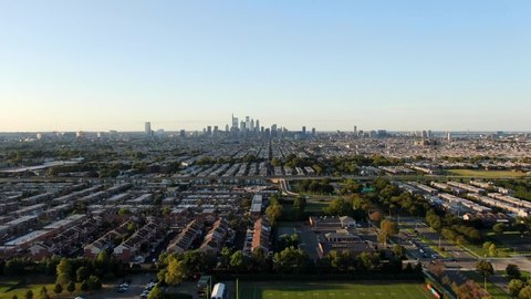 Aerial pull back shot above Southern Philadelphia revealing urban cityscape skyline of evening horizon