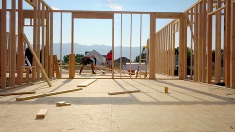 Layton , Utah / United States - 08 25 2019: A group of construction workers putting together the studs for walls and nailing them down. While they build the house.