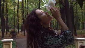Cute curly girl smiles and enjoys the flowers. Slow Beautiful vintage video.