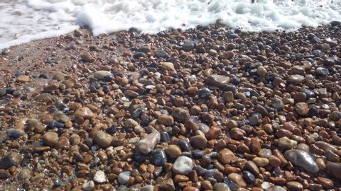 Slow motion of waves lapping the pebbles on Brighton beach, England, United Kingdom