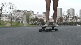 Beautiful girl from Russia riding a skateboard on the street. Modern girl in motion.