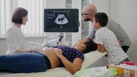 Pregnant woman and her family on utltrasonographic examination at hospital