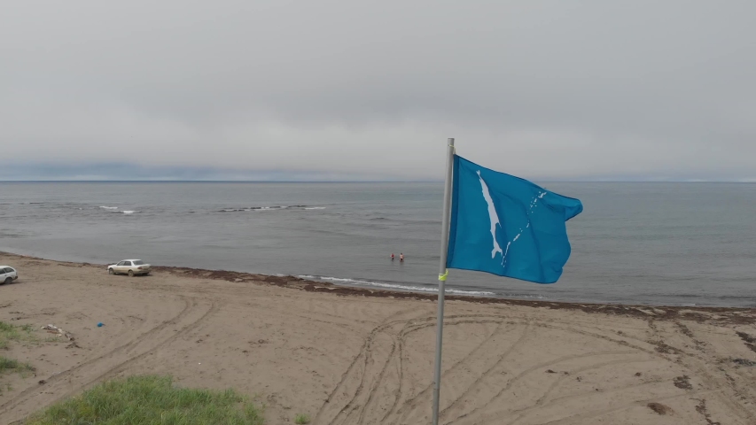 the coast of Sakhalin island and the flag of the region