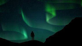 Aurora Borealis Green fluor Northern Lights and silhouette man watching. Winter landscape with polar weather in Arctic, Norway,Canada,Finland,Iceland, Sweden. Starry night sky scenery background 4k - Powered by Shutterstock - Get 15% off with code: PIKWIZARD15
