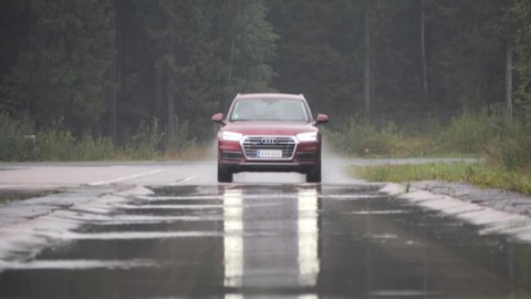 NOKIA, FINLAND - August 25, 2019: Audi Q5 driven by professional driver car drives through puddle projecting huge splash of water. This test is to estimate longitudinal aquaplaning (hydroplaning).