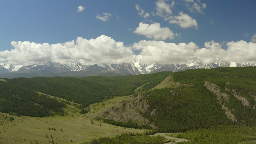 Beautiful spring landscape with mountains, forest and river. Aerial View. Drone shot over a beautiful mountain forest river.