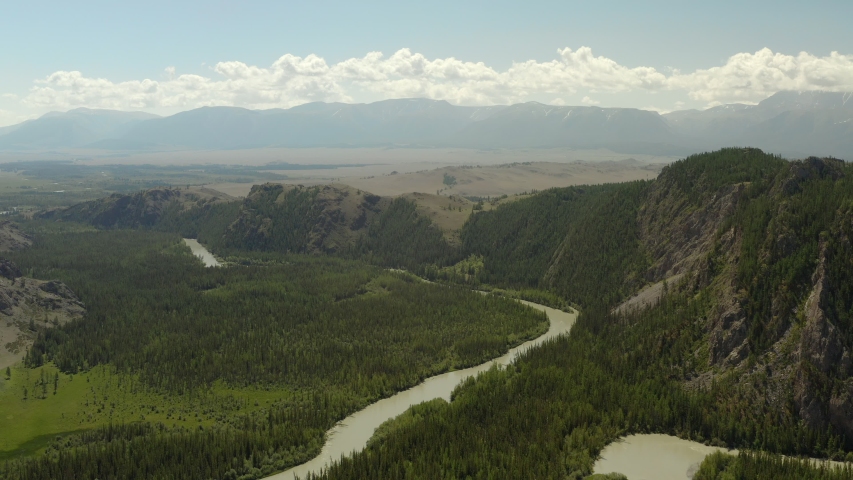 Beautiful spring landscape with mountains, forest and river. Aerial View. Drone shot over a beautiful mountain forest river.