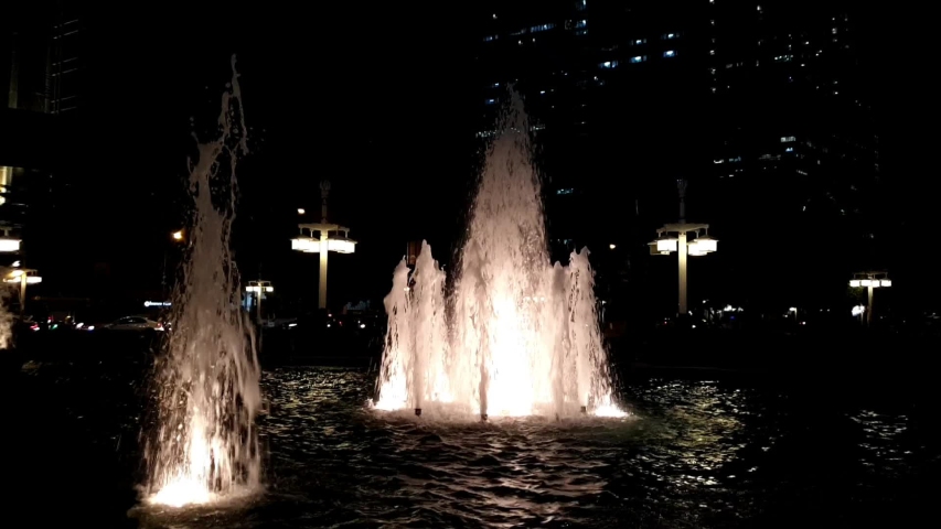 fountain in evening at public park near main road.