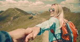 Woman tourist traveler walking on the top of mountain in summer sunny day under sun light. Beautiful mountains landscape view. 4K slow motion video, Concept follow me freedom.
