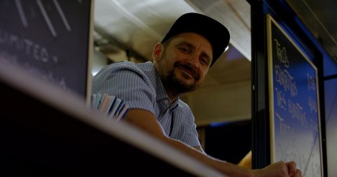 MED portrait Happy smiling middle-aged small business owner posing inside his Mexican food truck. 4K UHD RAW graded footage