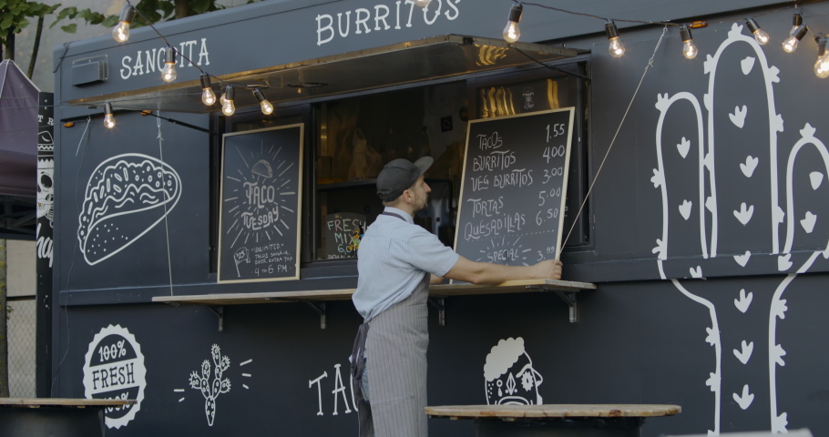 WIDE Happy smiling middle-aged small business owner posing near his Mexican food truck. 4K UHD RAW graded footage Royalty-Free Stock Footage #1036696850