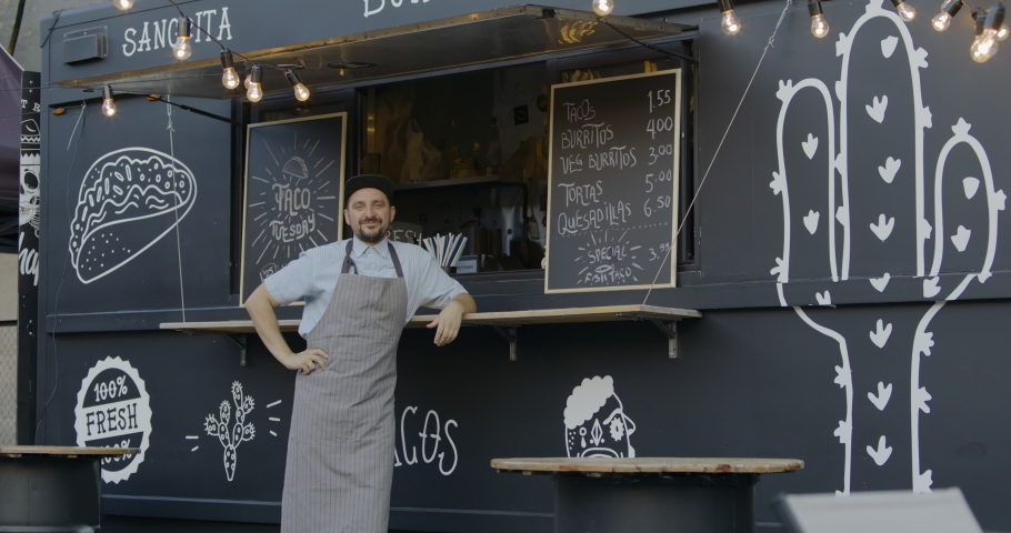 WIDE Happy smiling middle-aged small business owner posing near his Mexican food truck. 4K UHD RAW graded footage | Shutterstock HD Video #1036696850