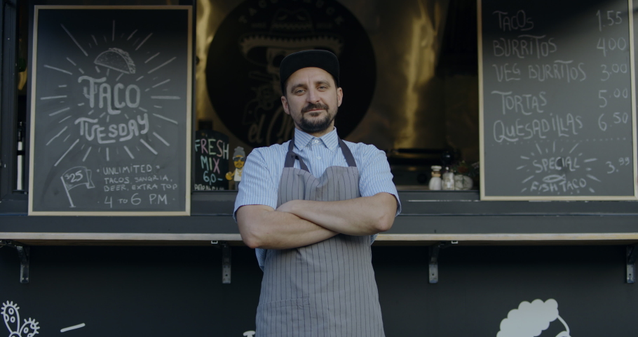 MED portrait Happy smiling middle-aged small business owner posing near his Mexican food truck. 4K UHD RAW graded footage