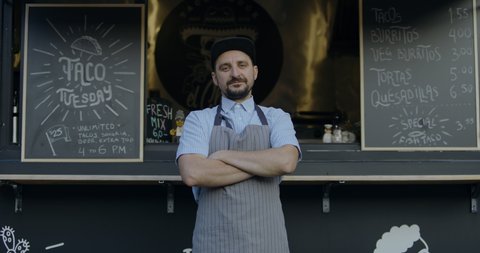 MED portrait Happy smiling middle-aged small business owner posing near his Mexican food truck. 4K UHD RAW graded footage