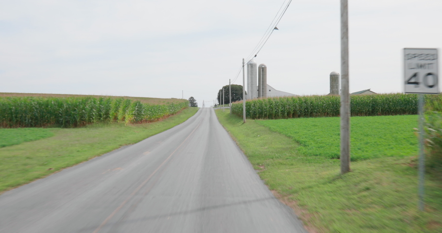 Drive Through Scenic Rural Farmland with Barn and Silos