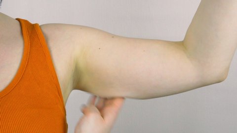 A woman checks her hands for excess fat. Flabby skin of the forearm. Obesity problem