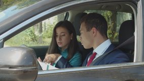 Attractive mixed race business colleagues analyzing financial charts and documents while sitting in car. Successful multiethnic business partners reviewing financial reports during business travel. - Powered by Shutterstock - Get 15% off with code: PIKWIZARD15