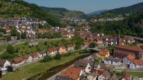 Aerial view of the city Weisenbach in Germany on a sunny day in summer. Pan to the left across the river.