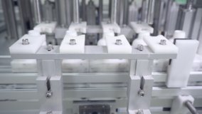 White plastic bottle on production line of conveyor at filling machine on conveyer belt factory. Close-up. Move the camera slider forward.