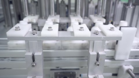 White plastic bottle on production line of conveyor at filling machine on conveyer belt factory. Close-up. Move the camera slider forward.