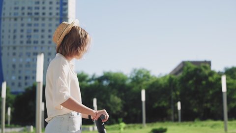 Young beautiful woman riding an electric scooter to work, modern girl, new generation, electric transport, ecology, ecological transport, sunset, electric skateboard