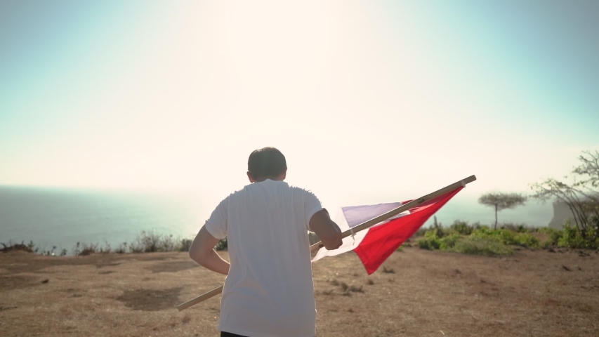 asian man with indonesian flag of indonesia on top of the mountain Royalty-Free Stock Footage #1036731953