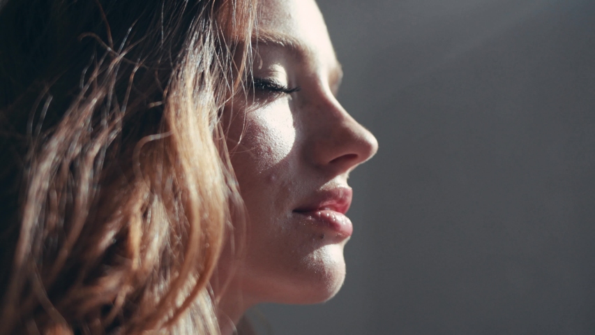 Close-up portrait of attractive young woman with cute freckles looking at sun in the apartment feel happy the sun is shining slow motion Royalty-Free Stock Footage #1036735718