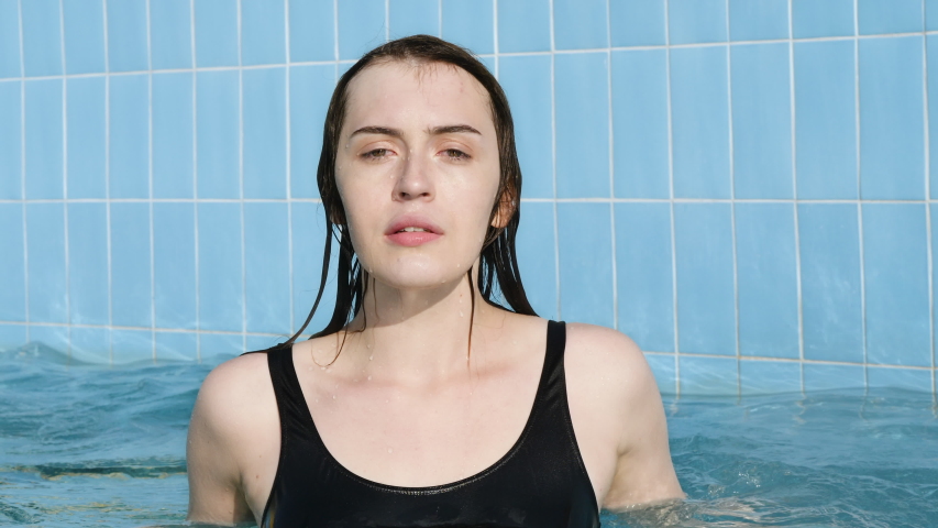 young woman emerges water pool blue Stockvideoklipp (helt royaltyfria) 1036...