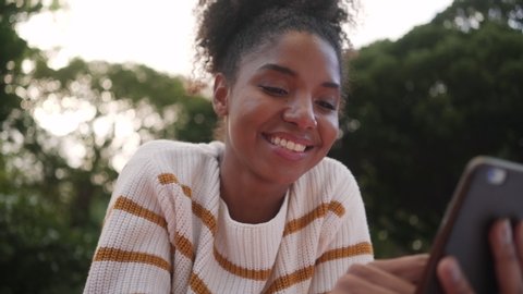 Low angle view of an african american young woman at outdoors using smartphone in brazil