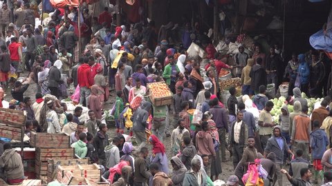 ADDIS ABABA, ETHIOPIA – MARCH 2019: Africa economy and urbanization - people buy food at bustling fruit and vegetable market in suburbs of Addis Ababa, chaotic crowds in Ethiopia