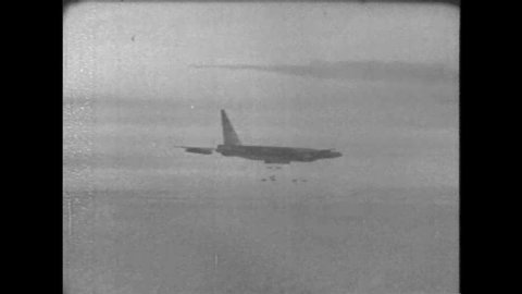 CIRCA 1960s - A Boeing B-52 Stratofortress strategic bomber drops bombs and warplanes fire missiles during the Vietnam War.