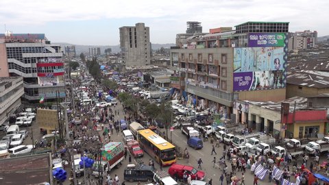 ADDIS ABABA, ETHIOPIA – MARCH 2019: Overview of busy Mercato marketplace with crowds of people and traffic jam, suburbs of Addis Ababa in Ethiopia