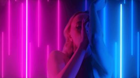 Girl Dressed In Black Is Dancing Slowly In Neon Lights. Perfect Female Body With Neon Stripes On The Background In The Night Club. Fashion Art Video