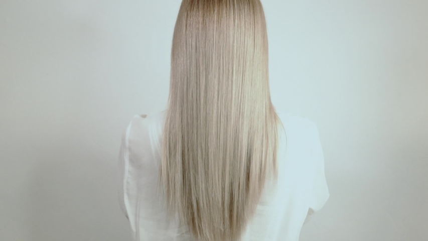 
Well-groomed, blond, long hair crumbles on a white background. Hair advertisement. Beautiful blonde hair view from the back. Hair after salon procedures Royalty-Free Stock Footage #1036764968