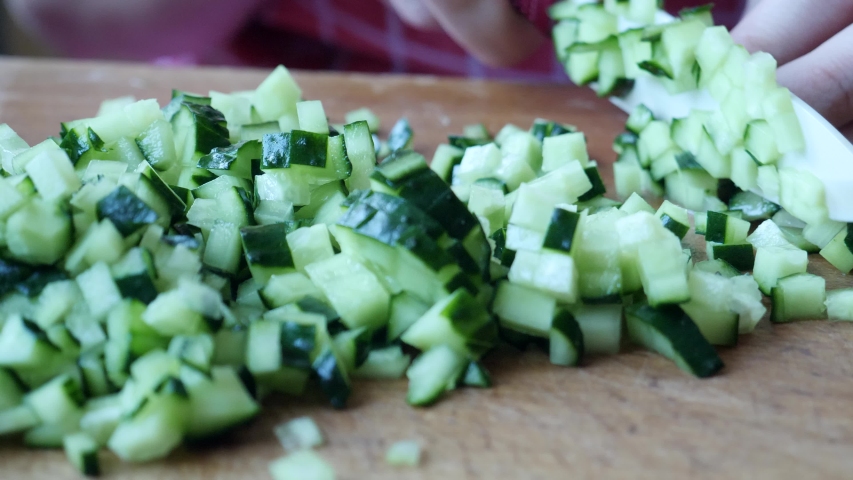 Chef female slices green ripe cucumber in kitchen at home preparing vegetable salad | Shutterstock HD Video #1036778069