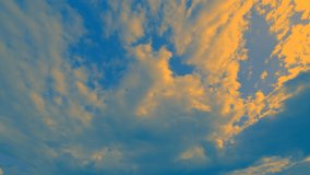 Yellow clouds against a bright blue sky in motion. Faster video recording of atmospheric phenomena on a wide-angle lens.
