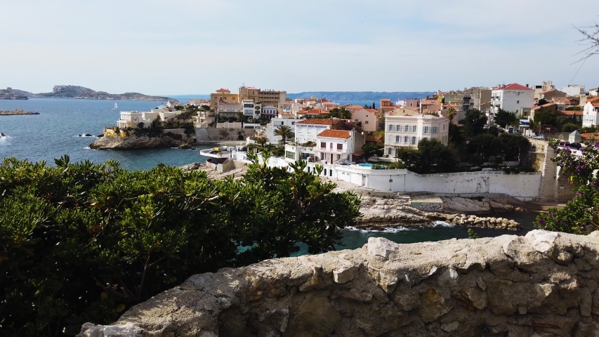 Sea shore village in Marseille city. Cinematic UHD 4K long wide shot. South France. French, Mediterranean and European life, travel, culture, politics, economics, history. Sunny spring or summer day. 
